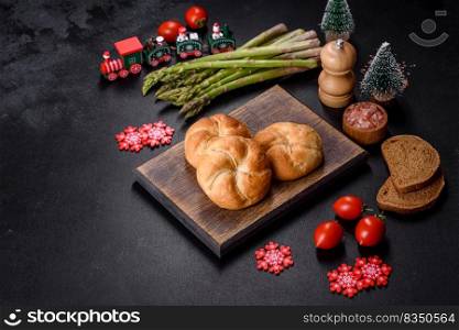 Crusty round bread rolls, known as Kaiser or Vienna rolls on a christmas table, flat lay on rustic background with text space. Crusty round bread rolls, known as Kaiser or Vienna rolls on a christmas table