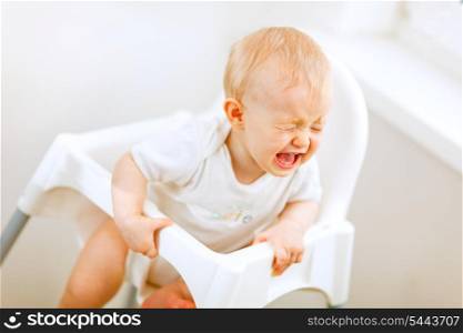 Crying baby in baby chair&#xA;