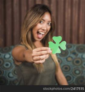 crying happy woman holding green paper clover