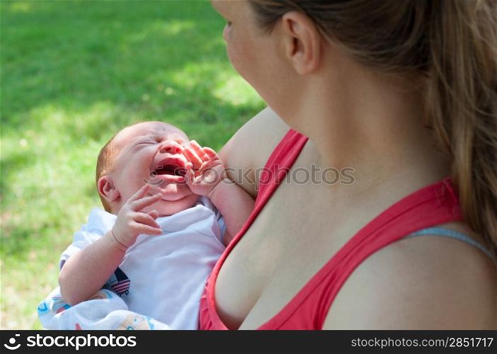 Crying Newborn Baby and Mother From Behind Outdoors