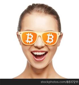 cryptocurrency and e-commerce concept - happy teenage girl in sunglasses with bitcoin signs reflection. happy girl in glasses with bitcoin signs. happy girl in glasses with bitcoin signs