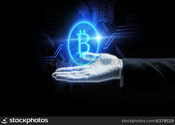 cryptocurrency, finance and business concept - close up of businessman hand with virtual bitcoin symbol hologram over black background. close up of businessman hand with bitcoin symbol
