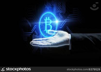 cryptocurrency, finance and business concept - close up of businessman hand with virtual bitcoin symbol hologram over black background. close up of businessman hand with bitcoin symbol