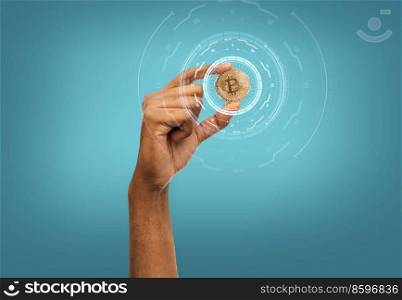 cryptocurrency, finance and business concept - close up of female hand holding golden bitcoin over blue background. close up of hand with bitcoin over blue