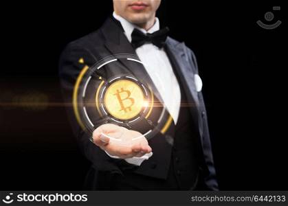 cryptocurrency, finance and business concept - close up of magician hand with virtual bitcoin symbol hologram over black background. close up of magician with bitcoin symbol