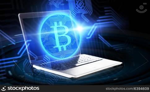 cryptocurrency, finance, business and future technology concept - laptop computer with bitcoin hologram over black background. laptop computer with bitcoin hologram