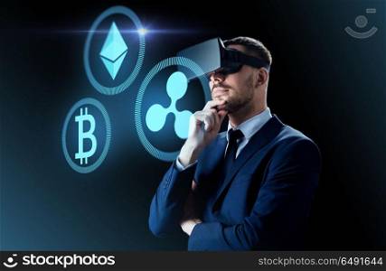 cryptocurrency, financial technology and business concept - businessman in virtual reality headset with ethereum, bitcoin and ripple holograms over dark background. cryptocurrency and businessman in virtual headset. cryptocurrency and businessman in virtual headset