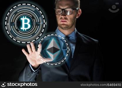 cryptocurrency, financial technology and business concept - businessman with ethereum and bitcoin holograms over black background. businessman with cryptocurrency holograms