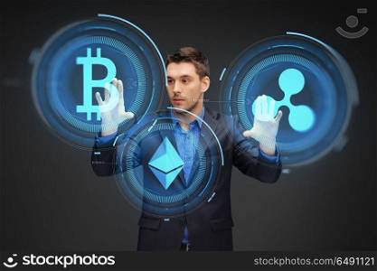 cryptocurrency, financial technology and business concept - businessman working with virtual bitcoin, ethereum and ripple hologram over dark background. businessman with cryptocurrency holograms. businessman with cryptocurrency holograms