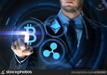 cryptocurrency, financial technology and business concept - close up of businessman with bitcoin, ethereum and ripple icons on virtual screen over dark background. businessman with at cryptocurrency icons. businessman with at cryptocurrency icons