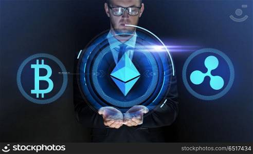 cryptocurrency, financial technology and business concept - close up of businessman with bitcoin, ethereum and ripple icons on virtual screen over dark background. businessman with at cryptocurrency icons. businessman with at cryptocurrency icons