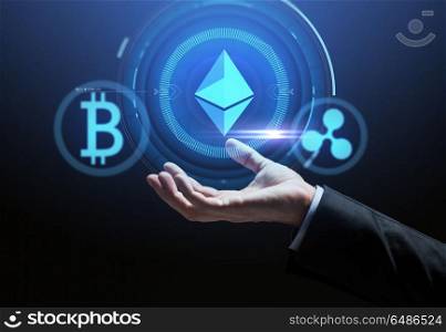 cryptocurrency, financial technology and business concept - close up of hand with bitcoin, ethereum and ripple icons on virtual screen over dark background. close up of hand with at cryptocurrency icons. close up of hand with at cryptocurrency icons