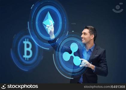 cryptocurrency, financial technology and business concept - smiling businessman working with virtual bitcoin, ethereum and ripple hologram over dark background. businessman with cryptocurrency holograms. businessman with cryptocurrency holograms