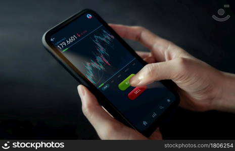 Cryptocurrency Investment Concept. Person Using Mobile Phone to Buy and Sell Bitcoin via Online Exchange Platform. Blockchain,Fintech Technology. Innovation of Financial Investment. Closeup shot