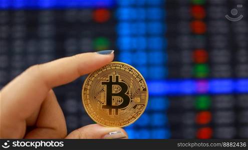 Cryptocurrency symbol bitcoin. Gold Digital Currency Money Investing in virtual assets. Hand hold Golden bitcoin Investment market trend financial world cryptocurrency and technology Concept.
