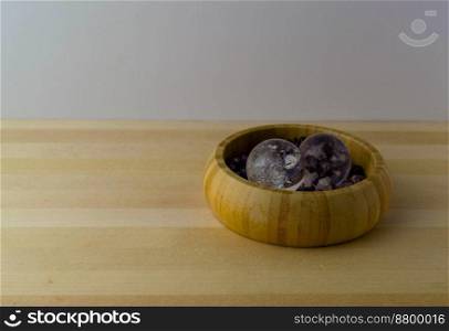 Crystal balls with amethyst stones on a wooden table.