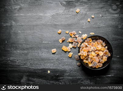 Crystal brown sugar. On black rustic background.. Crystal brown sugar.