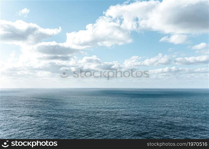 Crystal clear horizon of the ocean with white clouds with copy space, inspiration and freedom concept