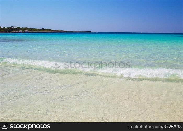 Crystal clear water and white sand at Cala Son Saura beach, Menorca island, Spain.