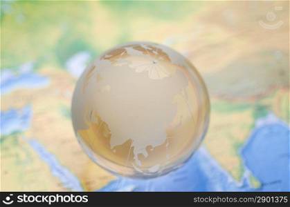 Crystal globe on global map. shallow DOF