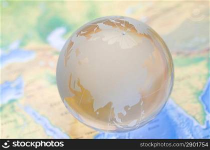 Crystal globe on global map. shallow DOF
