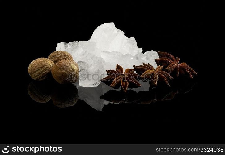 crystal sugar and spice over black reflective surface background