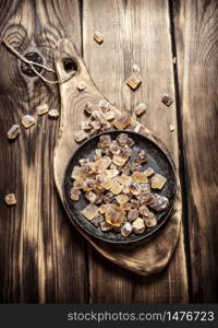 Crystalline cane sugar on the Board. On wooden background.. Crystalline cane sugar on the Board.