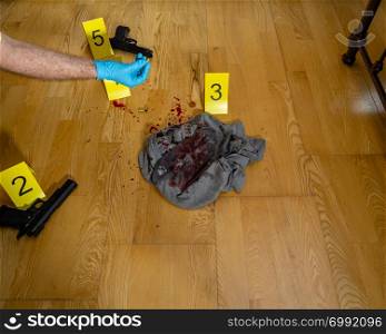 CSI forensices investigator inspects bullet casing at crime scene
