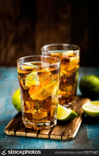 Cuba Libre or long island iced tea cocktail with strong drinks, cola, lime and ice in glass, cold longdrink