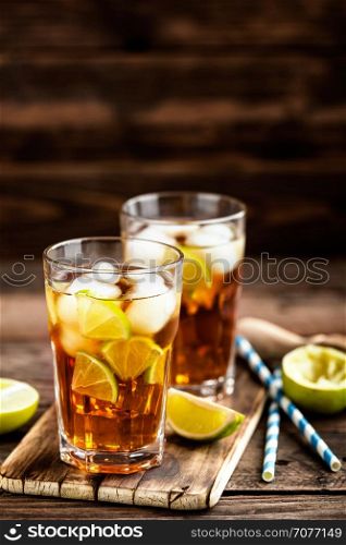 Cuba Libre or long island iced tea cocktail with strong drinks, cola, lime and ice in glass, cold longdrink
