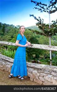 Cuba. The beautiful woman in a long blue dress in park of Soroa (Jardin Botanico Orquideario Soroa)