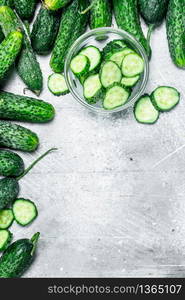 Cucumbers and pieces of fresh cucumbers in the bowl. On rustic background. Cucumbers and pieces of fresh cucumbers in the bowl.