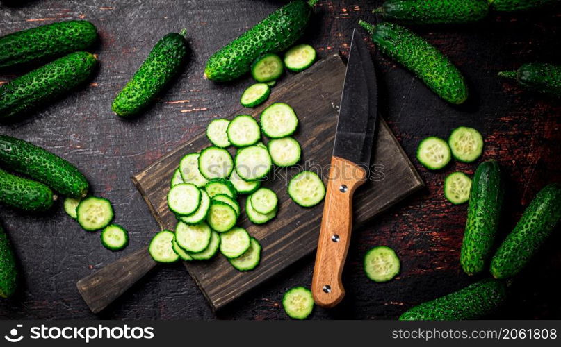 Cucumbers cut on a cutting board. On a black background. High quality photo. Cucumbers cut on a cutting board.