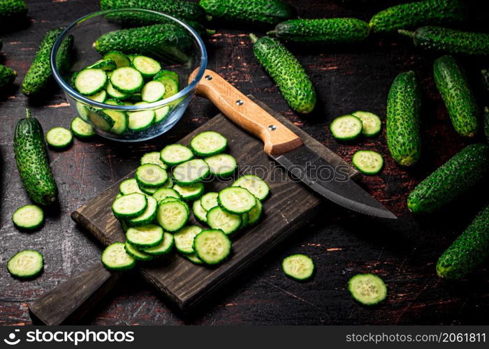 Cucumbers cut on a cutting board. On a black background. High quality photo. Cucumbers cut on a cutting board.