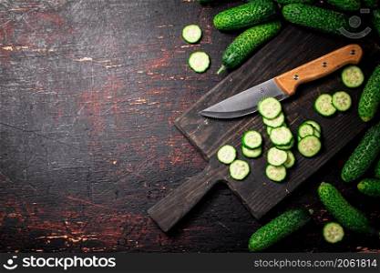 Cucumbers cut on a cutting board. On a black background. High quality photo. Cucumbers cut on a cutting board.