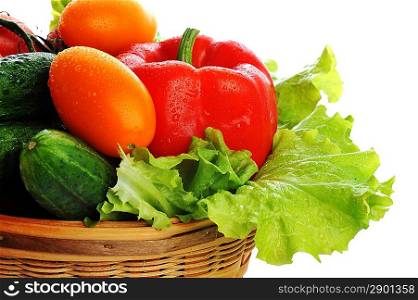 Cucumbers, red tomatoes and salad lie in basket