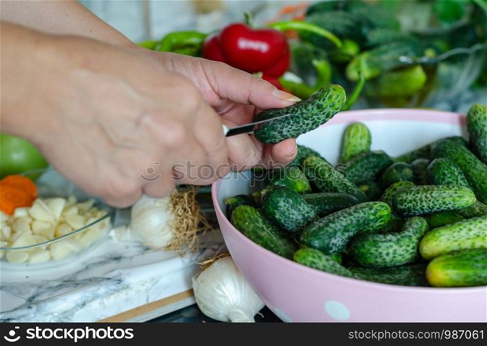 Cucumbers with garlic, salt and dill for pickling . The woman is preparing cucumbers to make pickles.