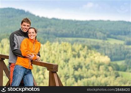 Cuddling couple on a summer weekend at the top of the mountain