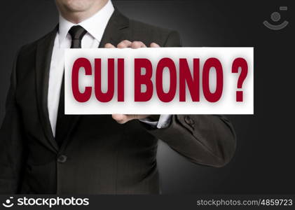 cui bono sign is held by businessman background. cui bono sign is held by businessman background.