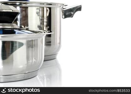 Culinary background - group of premium stainless steel pots and pans isolated on a white background with copy place.