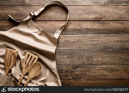 Culinary background, kitchen utensils and apron on kitchen countertop with blank space for any recipe or menu text