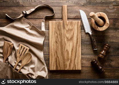 Culinary background, kitchen utensils and apron on kitchen countertop with blank space for any recipe or menu text