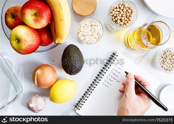 Culinary, cooking and healthy food concept. Food ingredients on white table with notebook for checklist