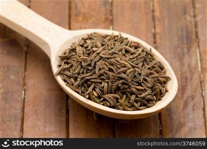 cumin seeds in wooden spoon