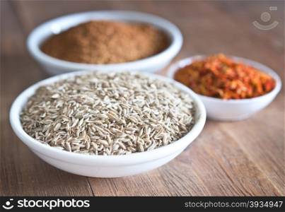 cumin seeds, saffron, ground red pepper on wooden table
