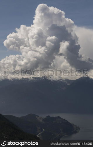 Cumulus cloud over mountains, BC Coast, Coast Mountains, Squamish, British Columbia, Canada