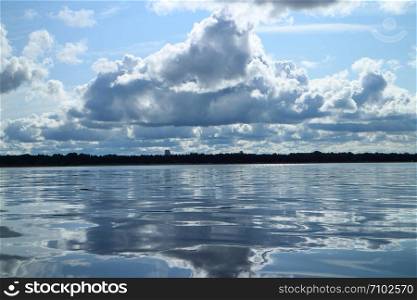 cumulus clouds reflected in the sea panorama