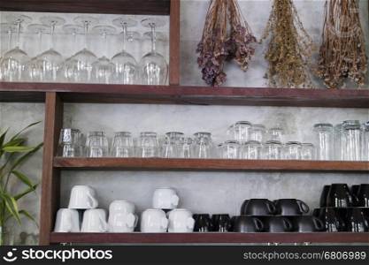cup and glass on wooden shelf for use as kitchen background