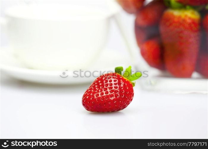 cup and strawberry in a glass bowl isolated on white