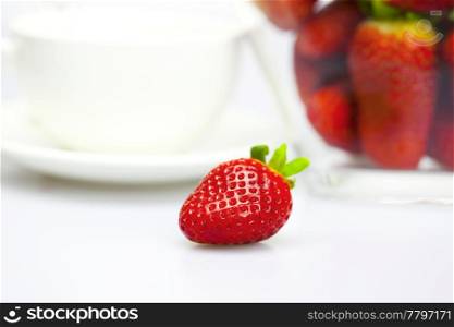 cup and strawberry in a glass bowl isolated on white